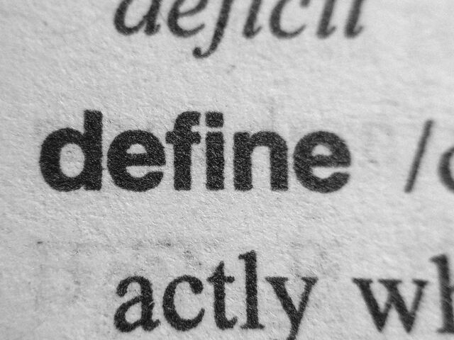 A close-up of printed text showing the words "deficit" and part of "activity" on textured paper, with a focus on the words "deficit" and "activity."