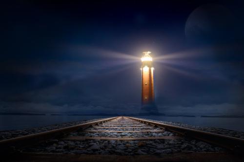 Lighthouse at night with rails visible in the front