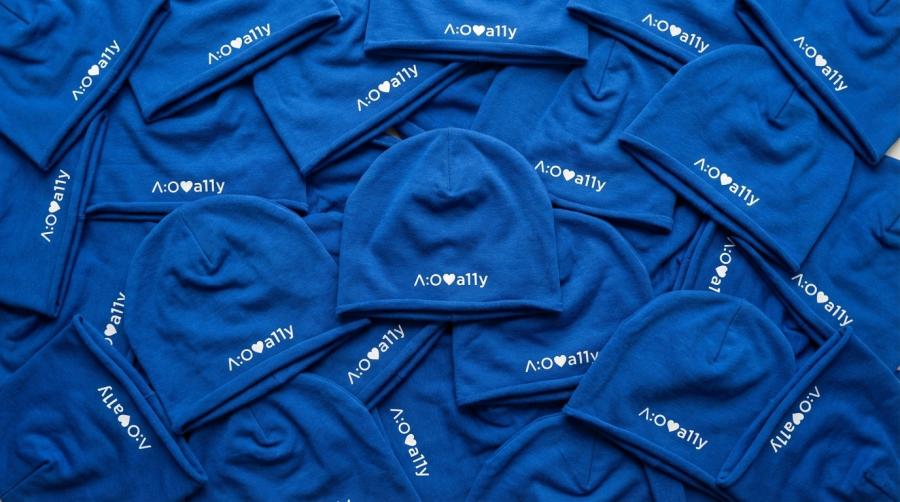 Blue beanies scattered, each with "a:o love a11y" in white text and a heart icon.