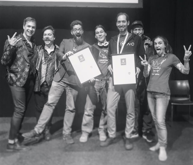 team acolono on stage holding nominations into the camera